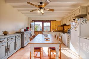a kitchen with a table and a ceiling fan at Maison Callen in Festalemps