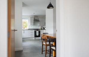 a kitchen with white cabinets and a table and chairs at The Old Post Office in Saasaig +33 photos
