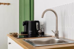 a kitchen counter with a sink and a coffee maker at AMS Cluj Central Stay Boutique in Cluj-Napoca +57 photos