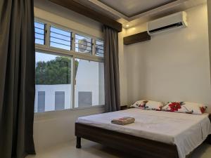 a bedroom with a bed and a window at Guestway Transient Inn in Calapan