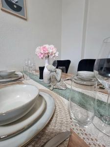 a dining room table with plates and glasses on it at Bahnhofsnahes Altstadt-Paradies in Cottbus