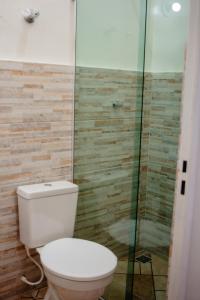 a bathroom with a toilet and a glass shower at Suítes Serra do Cipó 2 in Santana do Riacho +14 photos