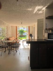Una cocina y un comedor con mesa y sillas. en Villa 305 Acapulco Diamante, en Acapulco