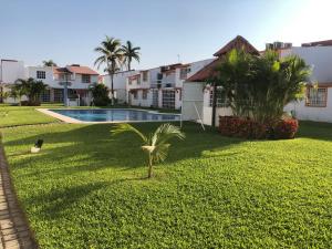 Un patio con una palmera y una piscina. en Villa 305 Acapulco Diamante, en Acapulco 13 fotos más