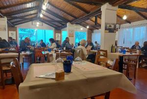 a group of people sitting at tables in a restaurant at Hotel Remin Plaza in Rimini