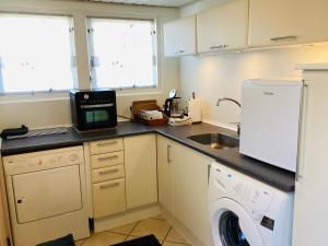 a small kitchen with a sink and a washing machine at Herning syd - Lind in Herning