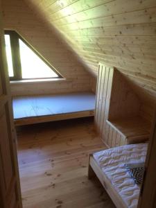 a small attic room with a bed and a window at Domek dla Młodzieży i Dorosłych W Sercu Mazur Różana in Ryn