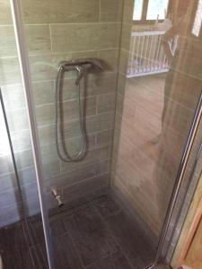 a shower with a glass door in a bathroom at Domek dla Młodzieży i Dorosłych W Sercu Mazur Różana in Ryn +3 photos