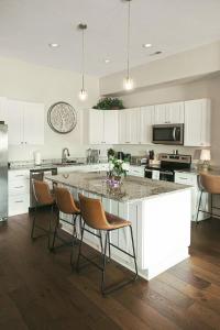 a kitchen with white cabinets and a large island with chairs at Spacious Freshly Renovated Townhome - City Side in Loudon