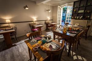 a dining room with a table and chairs and a room with tables at Hotel De L'Atelier in Villeneuve-lès-Avignon