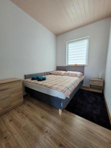 a bedroom with a bed and a window at Domki Eridan, nad morzem in Wisełka