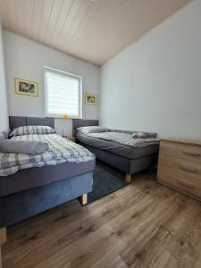 a bedroom with two beds and a window at Domki Eridan, nad morzem in Wisełka