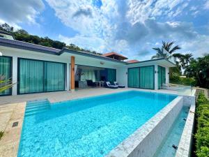 a swimming pool in front of a house at Sunterra villa in Nathon Bay