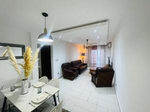 a living room with a table and chairs and a couch at Mich appart in Yaoundé