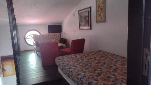 ein Schlafzimmer mit einem Bett und einem Stuhl in einem Zimmer in der Unterkunft Seu lar na Praia, Condomínio Vila Gustavo-excelente localização in Caraguatatuba + 26 Fotos