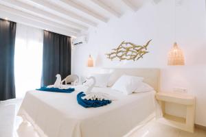 a white bedroom with two swans on a bed at HOTIDAY Room Collection - Naxos in Stelida