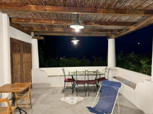 a patio with a table and chairs under a wooden ceiling at Nicaredda in Stromboli +12 photos