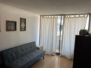 a living room with a couch and a large window at Providencia-MetroSalvador in Santiago