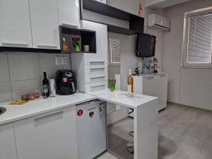a white kitchen with white cabinets and a refrigerator at M and M Apartment in Ohrid +9 photos