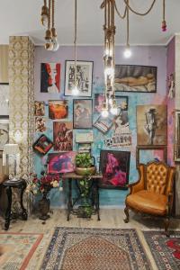 a room with a table and a wall with paintings at Creative retreat and Artist Haven Bohemian Villa on Calea Victoriei in Bucharest +23 photos