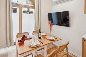 ein Esszimmer mit Tisch und Fernseher in der Unterkunft Lavie Maison Central & Hot Tub in Bordeaux