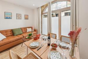 ein Wohnzimmer mit Tisch und Couch in der Unterkunft Lavie Maison Central & Hot Tub in Bordeaux