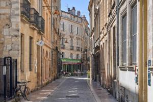 eine Gasse mit Gebäuden und ein Fahrrad auf einer Straße geparkt in der Unterkunft Lavie Maison Central & Hot Tub in Bordeaux