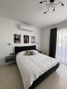 a white bedroom with a large bed and a window at Sliema Penthouse 3 Ensuite Bedrooms Seaview - Zero55 in Sliema