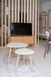 a living room with two tables and a flat screen tv at Apartamento Don Marcos B in Badajoz