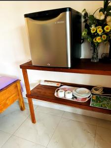 a television on a wooden table with plates and bowls at Ella viewpoint sunnyview in Ella