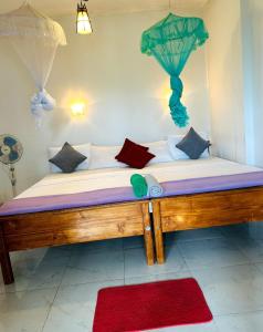 a large bed with pillows and an umbrella on it at Ella viewpoint sunnyview in Ella