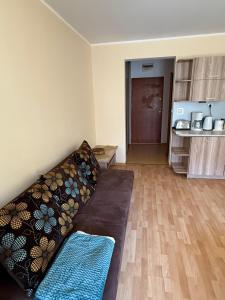 a living room with a couch and a kitchen at Apartament Muzungu in Świnoujście