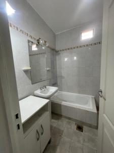 a white bathroom with a sink and a tub and a mirror at Casa ciudad de San Luis in San Luis +32 photos