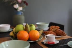 a table topped with plates of fruit and coffee cups at Cozy Apartment in Antwerp central in Antwerp +8 photos