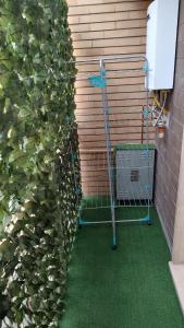 a green lawn in front of a wall with a garden at Room&Board 2 Bedrooms up to 7 beds 1 Bathroom in Voghera