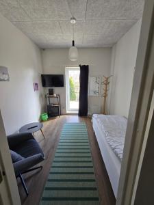 Store MerløseSkee overnatning的一间卧室，里面有一张床、一把椅子和一扇窗户