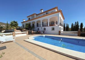 a large villa with a swimming pool in front of it at Spacious Villa with Exceptional Views in Malaga in Casarabonela