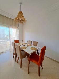 ein Esszimmer mit einem weißen Tisch und Stühlen in der Unterkunft Cosy 2 S prêt du carrefour in Sidi Daoud