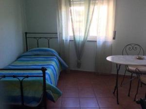 - une chambre avec un lit, une table et une fenêtre dans l'établissement B&B Spano', à Reggio de Calabre