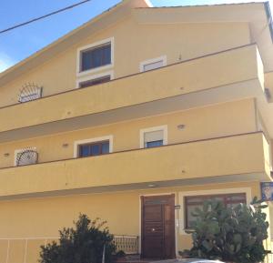 un bâtiment jaune avec une porte marron dans l'établissement B&B Spano', à Reggio de Calabre