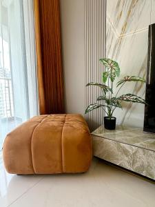una gran otomana marrón en una habitación con una planta en Deluxe 3 Bed 3 Bath Apartment, en Johor Bahru
