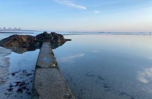 a rock in the middle of a body of water at Eden House - Beach Apartments & Suites in Saint Helier Jersey