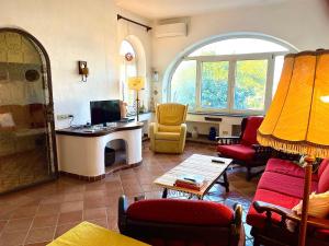 a living room filled with furniture and a large window at Villa Elke in Ischia Town