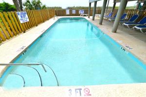 una grande piscina blu con sedie e recinzione di Windy Waves Top Location w Pool a Myrtle Beach