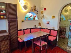 a dining room with a wooden table and red chairs at Villa Elke in Ischia Town