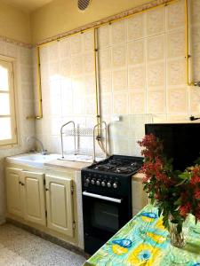 a kitchen with a black stove and a sink at Maison Tunisienne avec Patio in Sousse