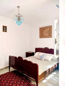 a bed with a couch in a room with a chandelier at Maison Tunisienne avec Patio in Sousse