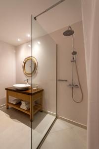 een badkamer met een douche met wastafel en spiegel bij La Maltese Residence in Imerovígli