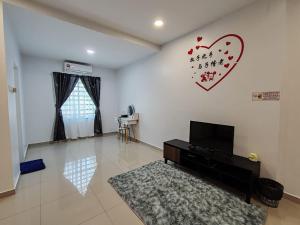 a living room with a tv and a heart on the wall at Loveu homestay 232 duyung in Seremban