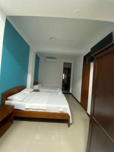 a bedroom with a bed and a blue wall at Hospedaje Caribe in Tarapoto
